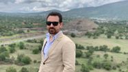 Portrait de DAMIEN SOITOUT avec des lunettes de soleil devant un paysage valloné